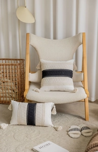 Detailed close-up of bohemian textured throw pillow with woven stripes and fringe tassels