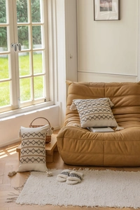 Detail of bohemian geometric embroidered pillow covers with tassels in a cozy home setting