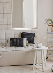 Detail of black and white jacquard throw pillows with bohemian tassels on a sofa