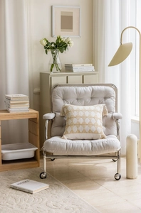 Detail of cream jacquard throw pillow with geometric patterns and fringe tassels