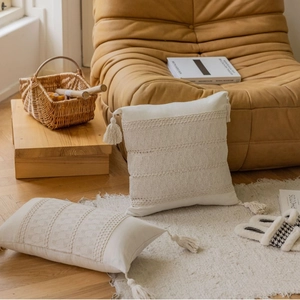 Beige boho throw pillow and lumbar cushion set with wave crochet and tassels on sofa