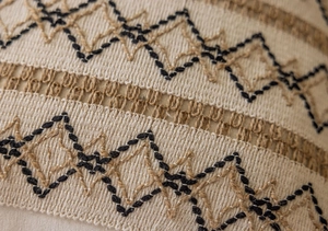 Detail of bohemian jacquard fabric featuring black geometric embroidery and hollow weaving