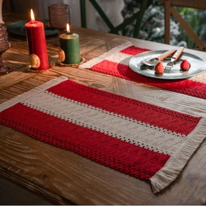 Striped cotton linen table runner with tassels on a rustic dark wood surface