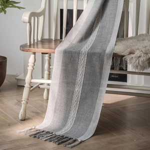 Nordic jacquard geometric table runner with grey stripes and tassels on a chair