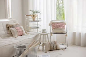Detail of bohemian decorative throw pillows with geometric weaving and tassels on a sofa