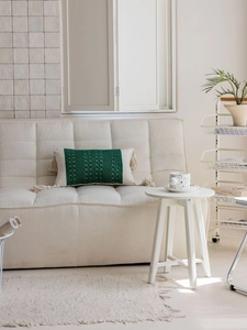 Detailed close-up of textured woven lumbar pillow with green accents and side tassels