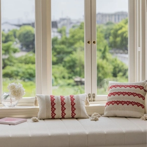 Bohemian style cream cushion covers with red heart embroidery and tassels on window seat