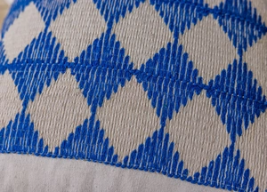 Macro shot of geometric blue embroidery on linen fabric cushion cover