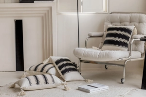 Detailed view of woven geometric wave patterns and tassels on textured cushion covers