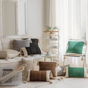 Bohemian knitted jacquard throw pillows with tassels on a white sofa in a cozy home