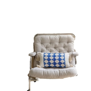 Blue geometric jacquard lumbar pillow with tassels on a modern armchair