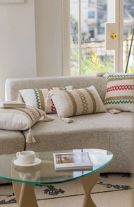Dettaglio del cuscino decorativo boho con ricami etnici e nappe sugli angoli