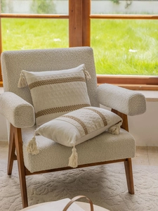 Detailed view of bohemian beige jacquard pillows with brown stripes and tassel accents