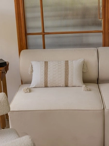 Detail of bohemian rectangle throw pillow with brown hollow weave and corner tassels