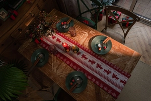 Detail of red and white Christmas table runner with reindeer and snowflake patterns