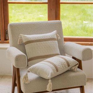 Bohemian cream throw pillow with brown woven stripes and decorative corner tassels