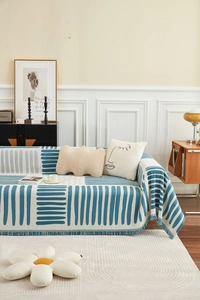 Detail van de blauw gestreepte bankhoes met franjes en decoratieve kussens