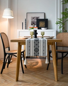 Dettaglio di runner da tavola nordico con motivi geometrici e frange bianche