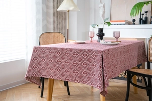Close-up of thick woven rectangular tablecloth with red and white geometric rhombus patterns