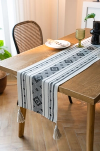 Dettaglio del runner da tavola jacquard geometrico bianco e nero con nappe decorative