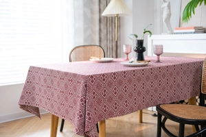 Detailed view of red and white geometric jacquard fabric texture on a long rectangle tablecloth