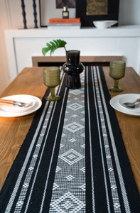 Macro shot of geometric jacquard patterns and cotton fringe on a boho style table runner