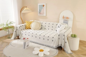 Detailed view of thick geometric woven sofa cover with grey squares and fringe edges