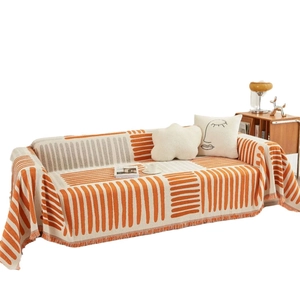 Moderne oranje en witte geometrische gebreide bankhoes met decoratieve kwastjes afwerking