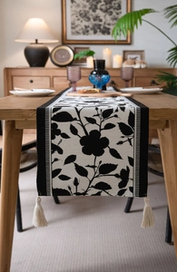 Macro shot of jacquard table runner with black white floral pattern and tassels