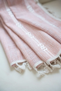 Texture détaillée du tissu à rayures orange avec glands blancs et broderie fine