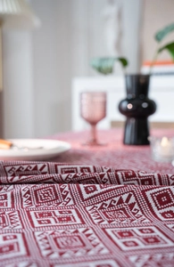 Close-up of red and white geometric jacquard tablecloth fabric with high texture