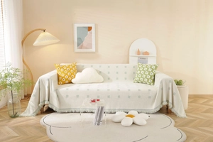 Detail of cream sofa cover with blue jacquard squares and delicate fringed edges