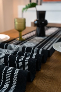 Close-up of bohemian table runner with jacquard geometric patterns and fringed edges