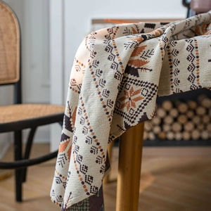 Nappe tissée ethnique bohème avec motifs floraux géométriques sur une table en bois rustique