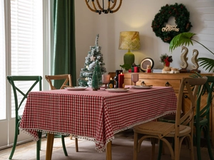 Detail van rood geruit katoen-linnen tafelkleed met witte pompons voor kerstversiering