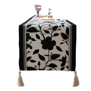 Jacquard table runner featuring black and white floral roses with elegant tassel edges