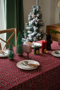 Detail van rood geruit kersttafelkleed met sneeuwvlokken en feestelijke decoraties