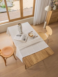 Detailed texture of beige linen tablecloth with 3D grid stitching on wooden table