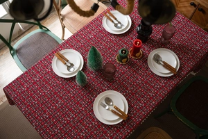Detail van rood feestelijk geruit tafelkleed met sneeuwvlokken en witte franjes rand
