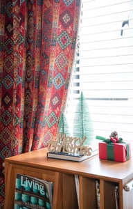 Macro detail of red festive curtains with bohemian jacquard geometric patterns and white tassels