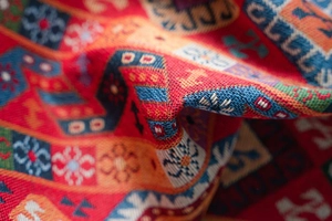 Close-up of red festive jacquard curtain fabric with ethnic geometric woven textures