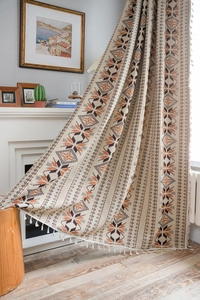 Detail of bohemian curtain with star patterns, cotton-linen texture and tassel fringe trim