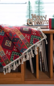 Close-up of red festive jacquard curtain with white fringe tassels and geometric patterns