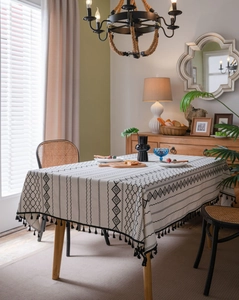 Détail d'une nappe en coton et lin bohème avec imprimé géométrique noir et franges