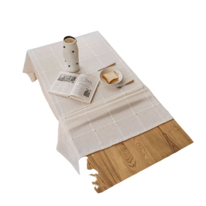 Cream plaid cotton linen tablecloth with 3D jacquard knots on a light wood dining table
