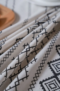 Détail de la nappe en lin bohème avec motifs géométriques noirs et texture artisanale