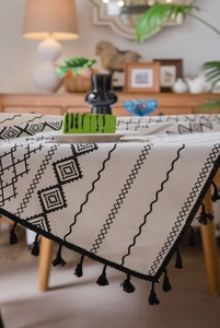Détail de la nappe bohème montrant la texture du tissu ethnique et les glands noirs