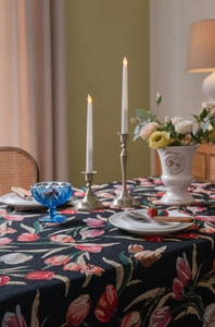 Detail einer dicken Jacquard-Tischdecke mit bunten Tulpenmustern auf schwarzem Stoff