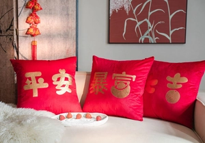 Detailed close-up of red velvet pillow covers with gold embossed Chinese calligraphy