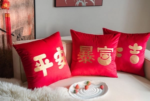 Detailed view of red velvet New Year pillow covers with gold embossed Chinese calligraphy